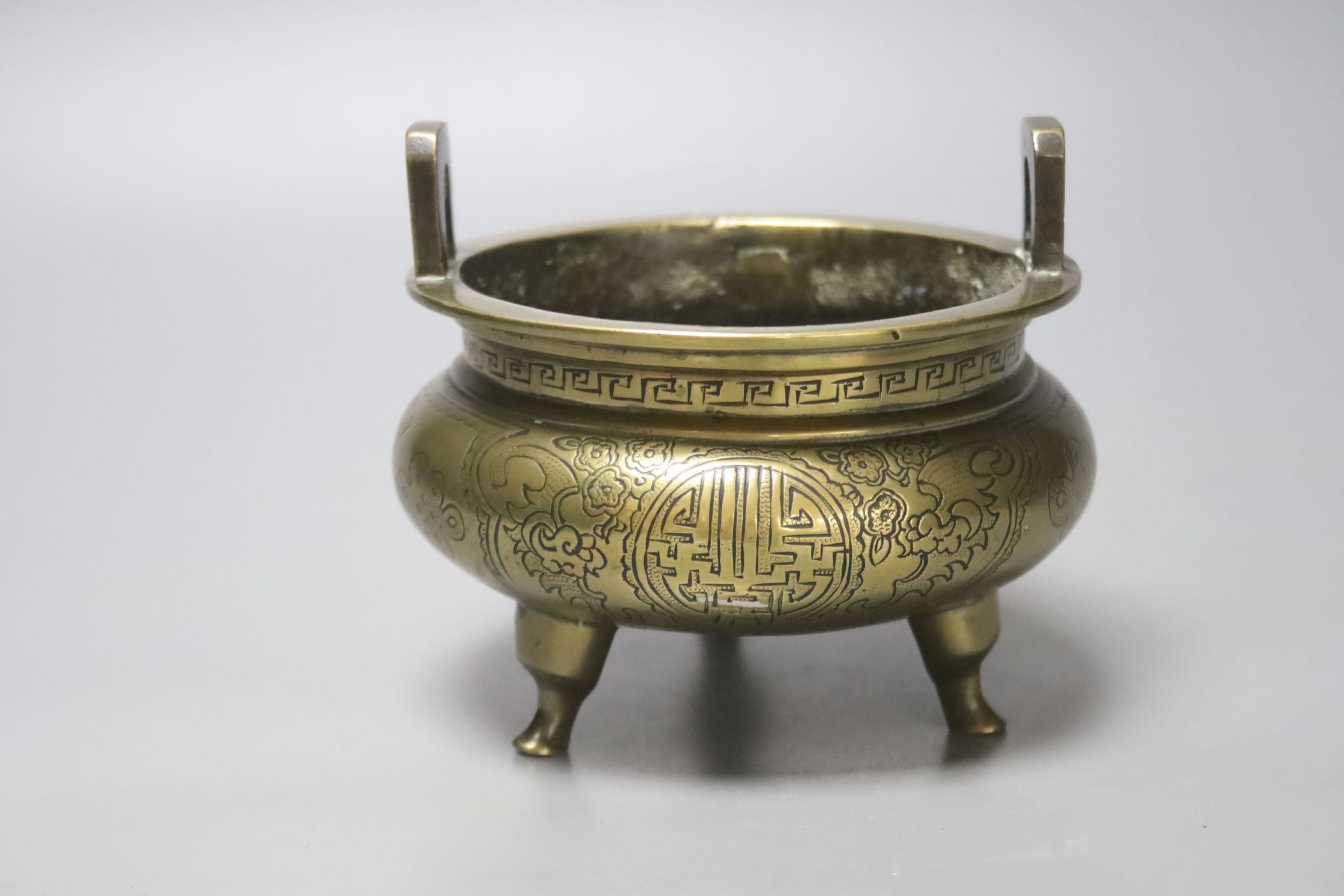 A 19th century Chinese engraved bronze tripod censer, Xuande mark to base, height 11cm